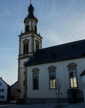 Außenansicht mit Blick auf Kirchturm und Kirchenschiff der Maria-Schmerz-Kirche